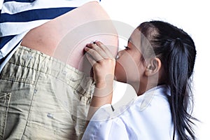 Little doctor listening with stethoscope for his unborn brother in his pregnant mothers belly