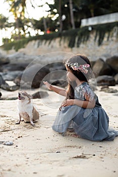 Little dog with girl relaxes on seacoast together having a good time