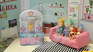 Little dolls with colored hair in dollhouse