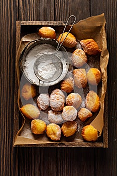 Little Donuts. Home-made cottage cheese cookies fried in deep fat and sprinkled with icing sugar in a vintage wooden box tray agai