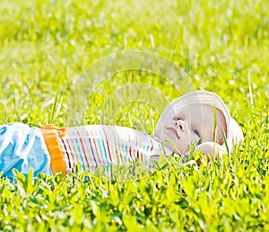 Little dreaming baby laying on the grass