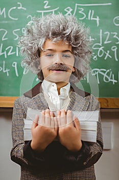 Little Einstein holding books in front of chalkboard