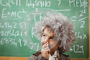 Little Einstein thinking in front of chalkboard