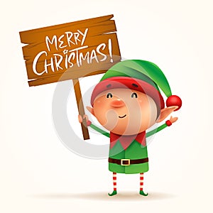 Little elf holds a wooden board with Christmas greetings. Isolated.