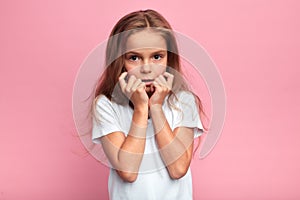 Little emotional beautiful girl looks shocked Isolated on pink.