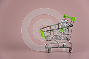 Little empty shopping cart on pink background