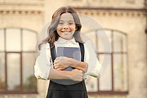 Little expert in books. Happy girl hold library book outdoor. School bibliopole. Bibliopole and bibliomania. Bibliopole