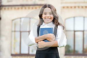 Little expert in books. Happy girl hold library book outdoor. School bibliopole. Bibliopole and bibliomania. Bibliopole