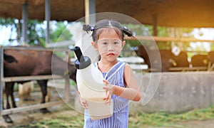 Little farmer girl holding milk bottle in farm. Feeding the murrah buffalo in farm