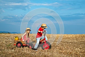 Little farmers kids in village. Beautiful children is riding the bicycle on countryside. Active kids. Outdoors.