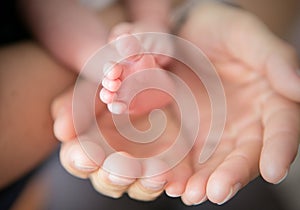 Little feet in Daddy's hands