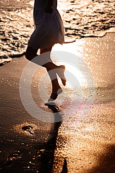 Little feet leave footprints on sandy shore of sea. walks on beach