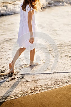 Little feet leave footprints on sandy shore of sea. walks on beach