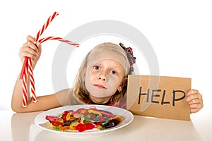 Little female child nutrition abuse of sweet and sugar in candy unhealthy food asking for help