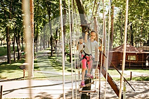 Little female climber leisures in rope park