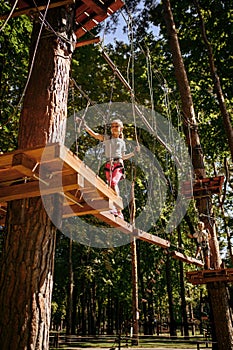 Little female climber leisures in rope park