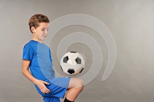 Little football player doing tricks with soccer ball
