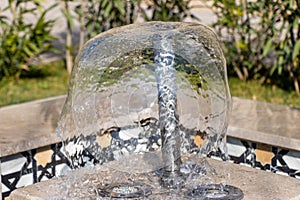 Little fountain. Transparent falling water vertical flows, close up