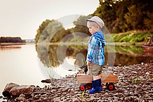 A little four years old sad boy looking for something on the river