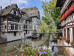 Little France, Strasbourg. Traditional houses decorated with flower arrangements, reflecting in the waters of the canal.