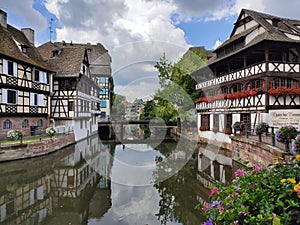 Little France, Strasbourg. Traditional houses decorated with flower arrangements, reflecting in the waters of the canal.