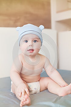 Little funny baby boy with big blue eyes smiling with cute cap with ears on his head