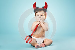 Little funny baby with devil horns and trident