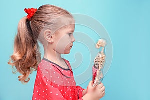 Little girl with glasses explore the structure of human body.