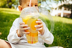 Little funny boy drinking a fresh  lemonade