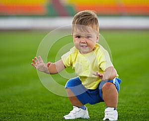 Little funny boy on football field