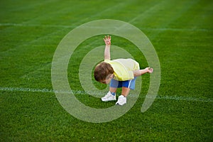 Little funny boy on football field
