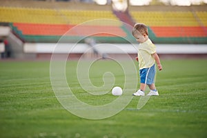 Little funny boy on football stadium