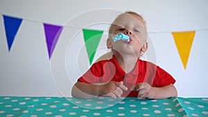 Little funny boy having fun and blowing party noisemaker. Gimbal motion