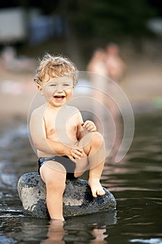 Little funny boy playing in water