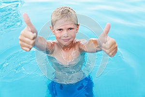 Little funny boy in the swimming pool