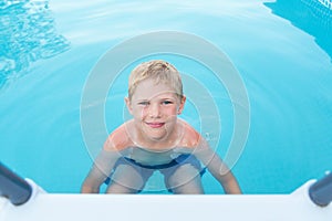 Little funny boy in the swimming pool