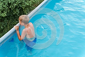 Little funny boy in the swimming pool