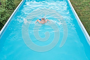 Little funny boy in the swimming pool