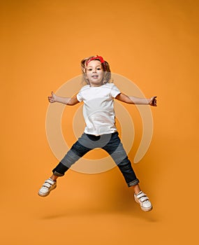 Little funny child baby girl jumping happy smiling laughing in white t-shirt with text copy space