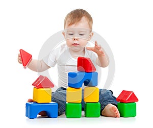 Little funny child playing with building blocks