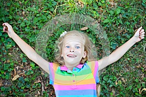 Little funny girl lying on grass