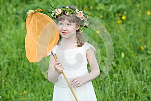 Little funny girl in white looks at butterfly
