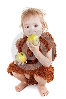 Little funny Neanderthal boy in a suit with dirty face eating an apple.