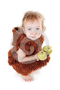 Little funny Neanderthal boy in a suit with dirty face eating an apple.