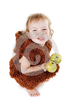 Little funny Neanderthal boy in a suit with dirty face eating an apple.