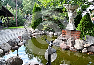 Little garden pond with miniature bronze sculptures