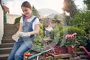 Little Gardener Ready to Bloom: Girl in Her Garden with Gardening Gloves On