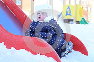 Little girl 11 months in warm clothes outdoor in winter