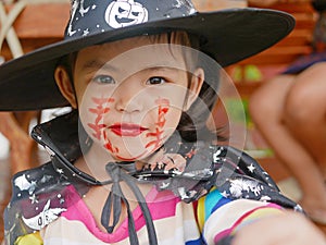 Little girl, 3 years old, is happy with her Halloween makeup and pretend playing as a powerful witch