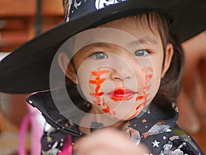 Little girl, 3 years old, is happy with her Halloween makeup and pretend playing as a powerful witch